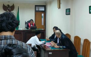 Terdakwa Perdana Arie berdiskusi dengan Penasihat Hukum BARA ADIL dalam sidang Pembacaan Tuntutan di PN Sleman (10/02/2026). Foto oleh Luisa/EKSPRESI.